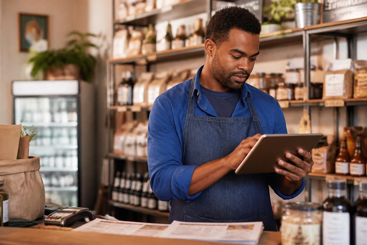 Lojista conferindo informações do negócio em um tablet